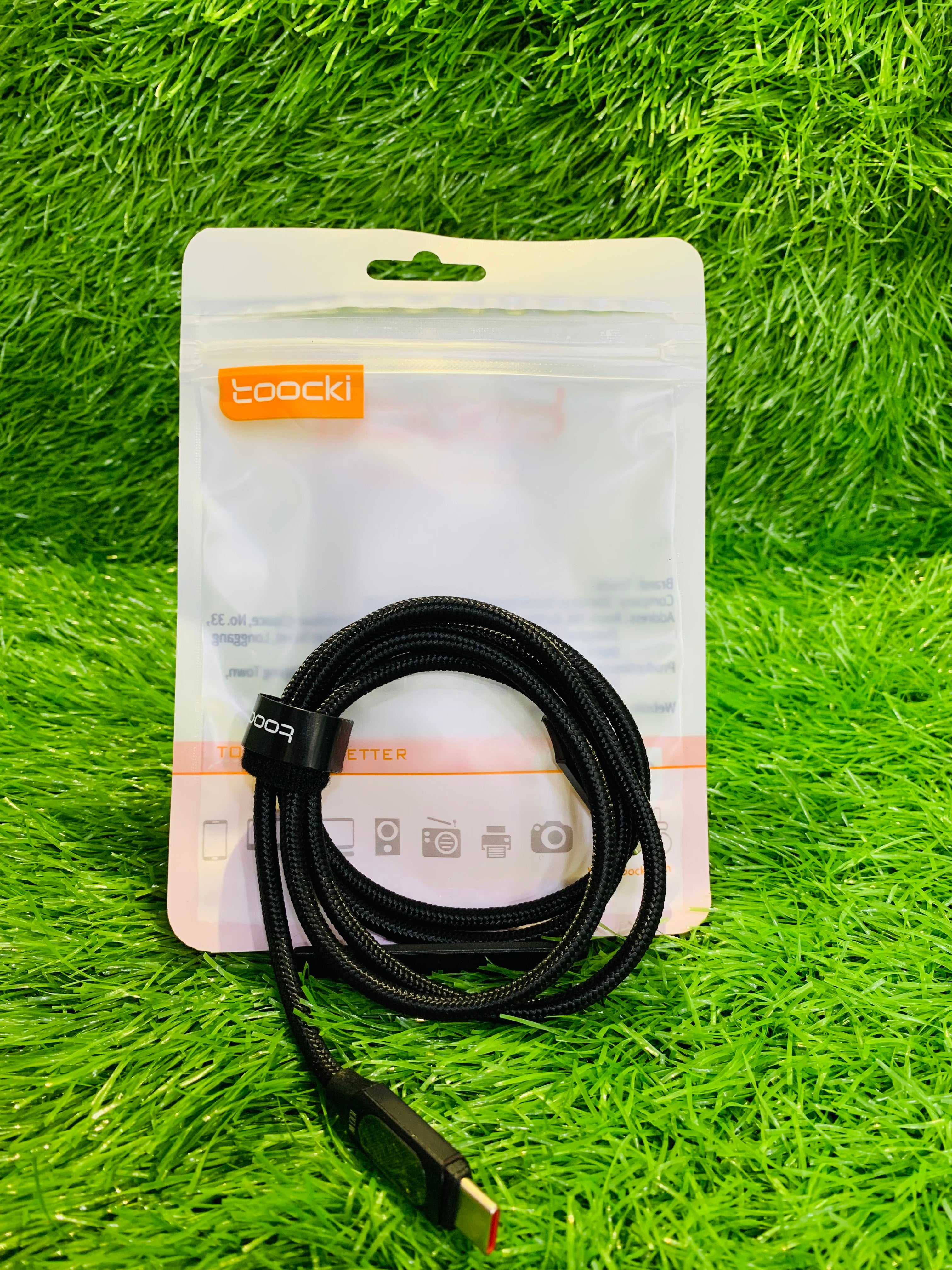 Black cable with packaging on a green grass background
